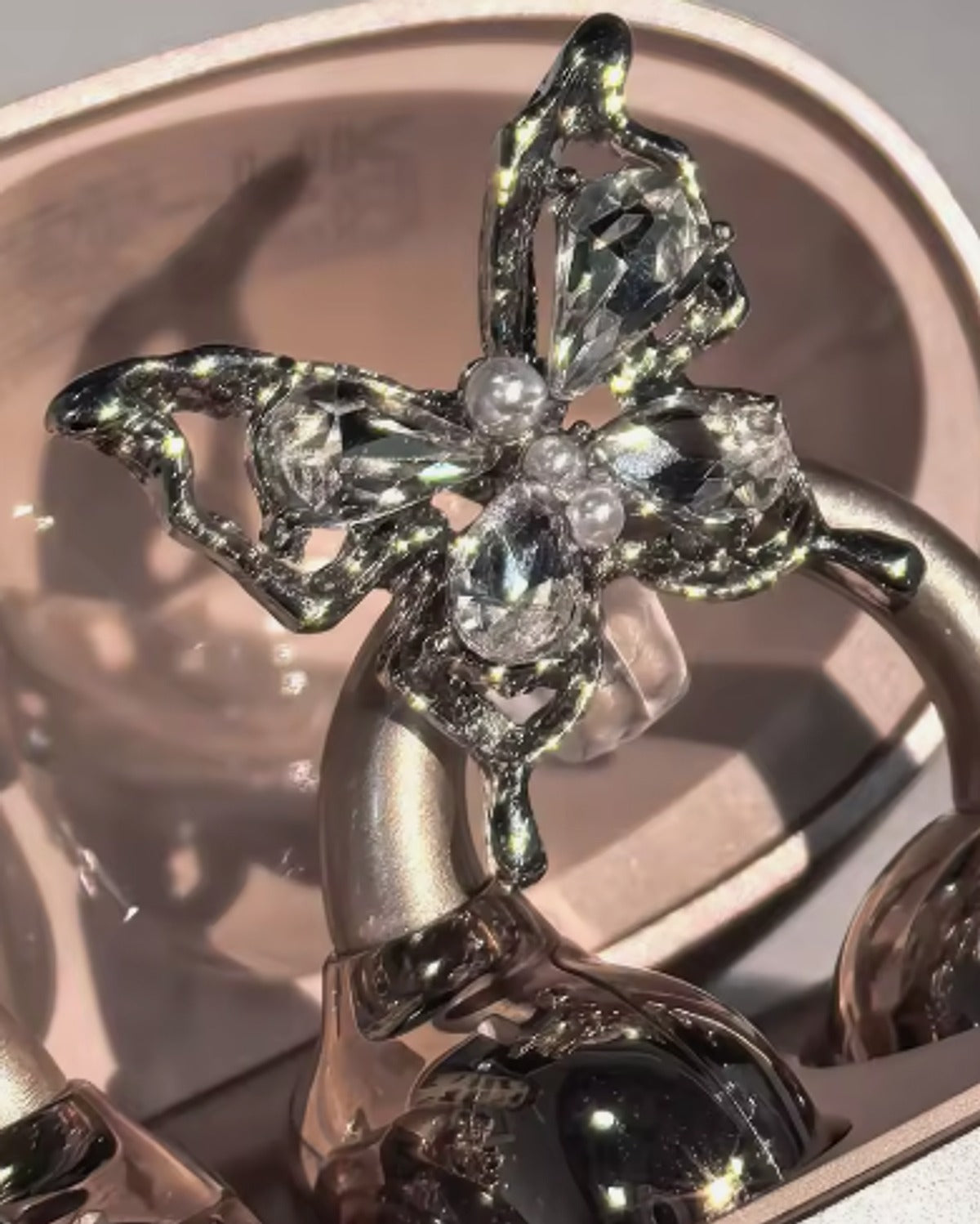 Charm papillon en métal argenté, cristaux et perles, clipsé sur l'écouteur-bijou